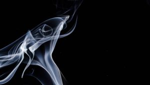 Wisps of tobacco smoke against a black background