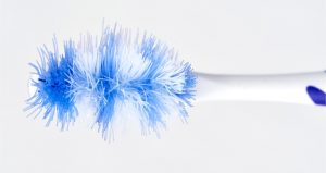 Overhead view of a blue and white toothbrush with frayed and smashed bristles