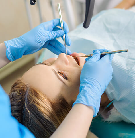 woman having her teeth cleaned at dentist's office
