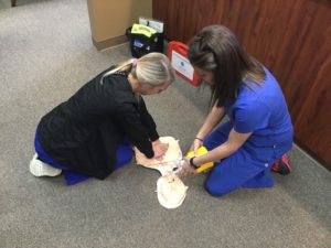The Troy Bartels, DDS team learns CPR on a dummy torso
