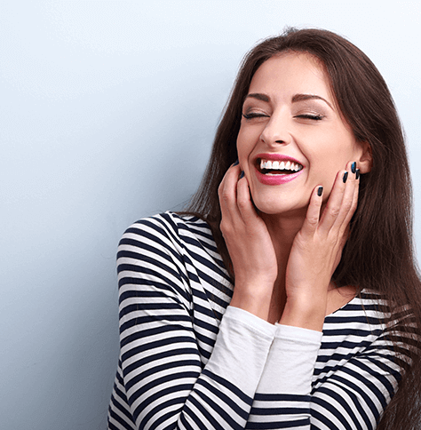 woman smiling and holding face